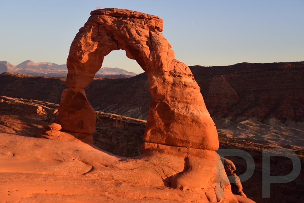 Delicate Arch with mountains in the distance in Arches National Park