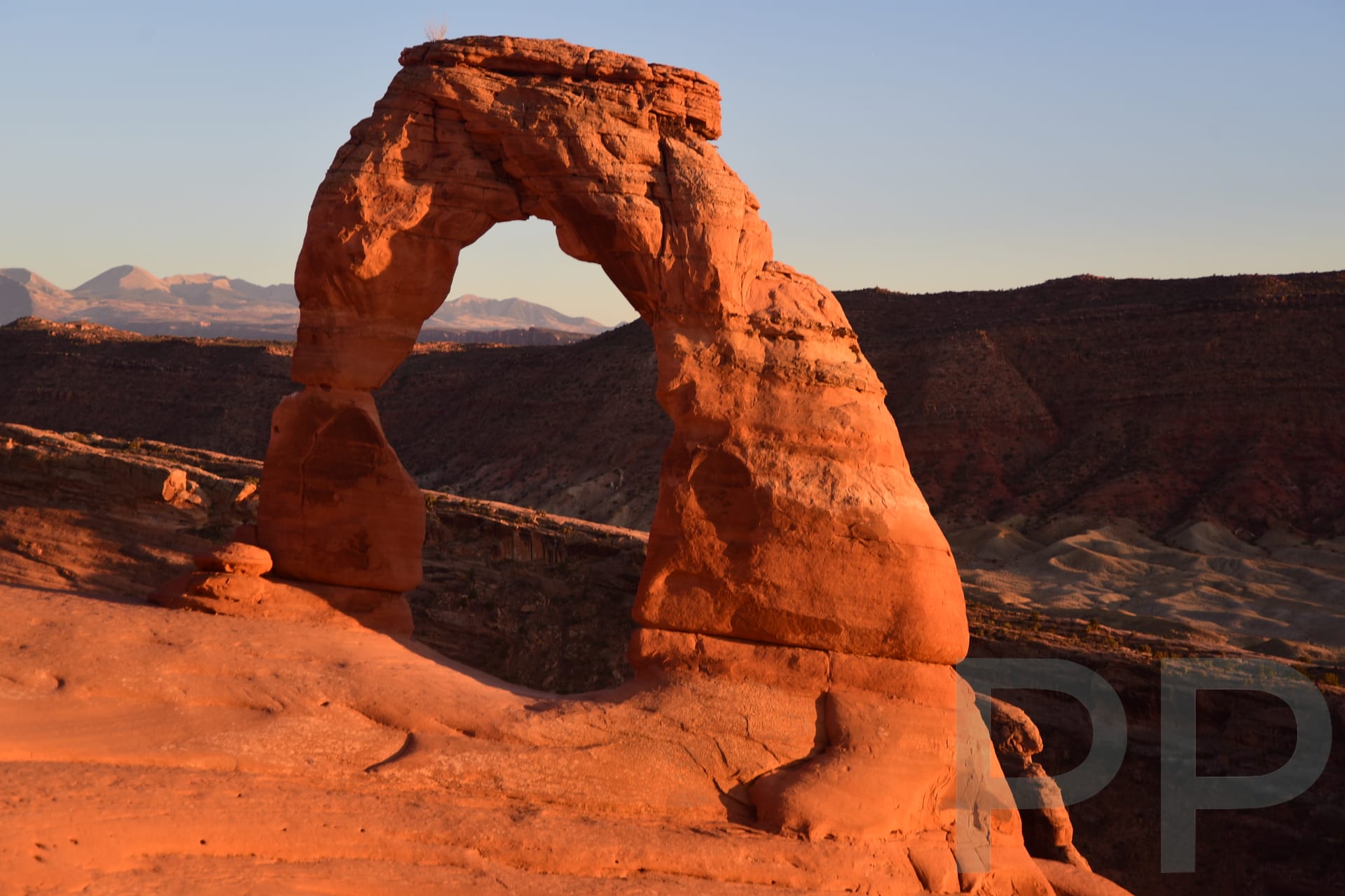 Delicate Arch with mountains in the distance in Arches National Park