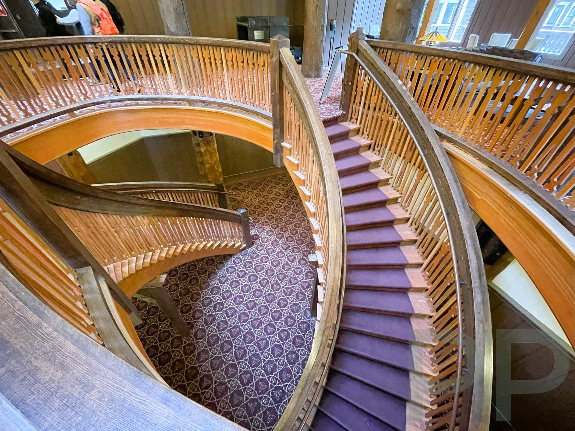 Curved wooden staircase inside Many Glacier Hotel leading to the Swiftcurrent Lake lakeshore