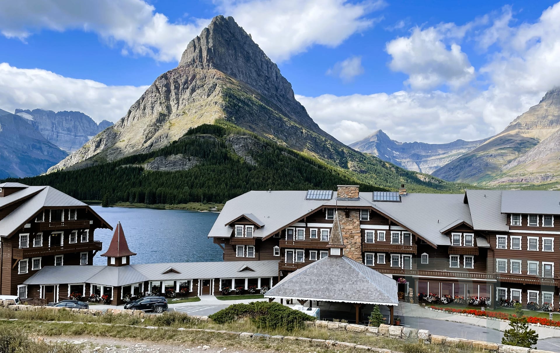 Many Glacier Hotel viewed from the parking lot with Swiftcurrent Lake and Grinnell Point in Glacier National Park