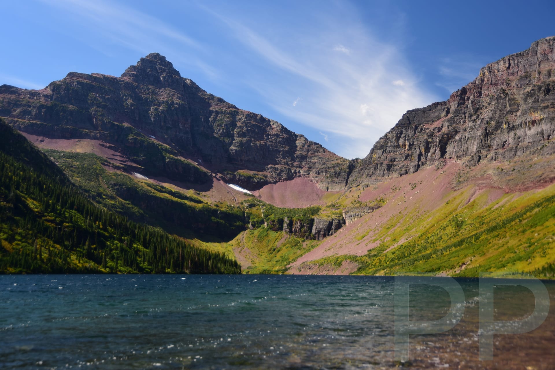 Alpine lake surrounded by steep rock walls in the Two Medicine area of Glacier National Park