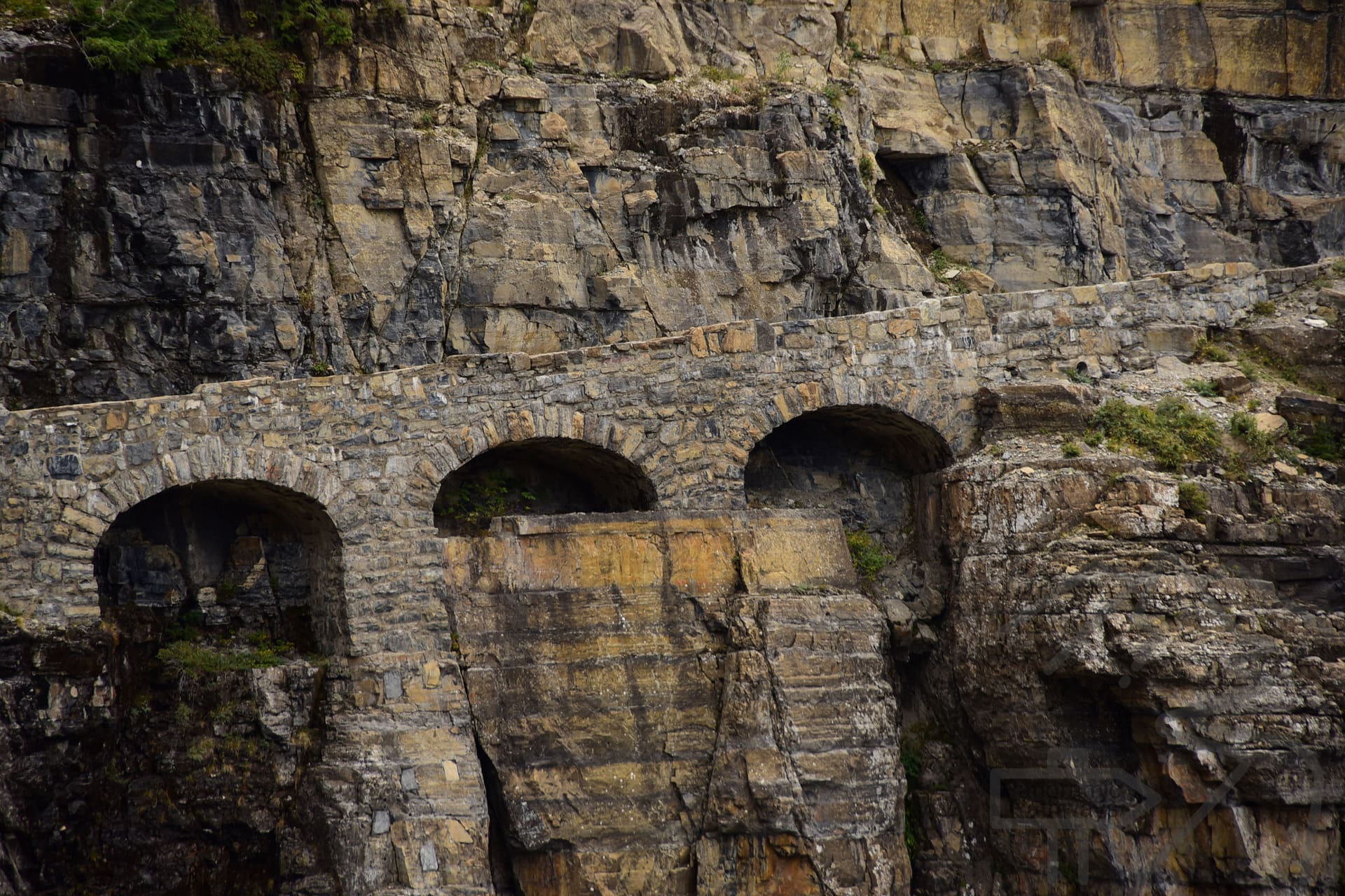 Triple Arches supporting Going-to-the-Sun Road along a steep mountainside in Glacier National Park