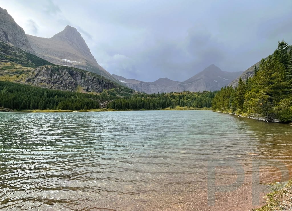 Redrock Lake with mountains and approaching storm clouds in the Many Glacier area of Glacier National Park