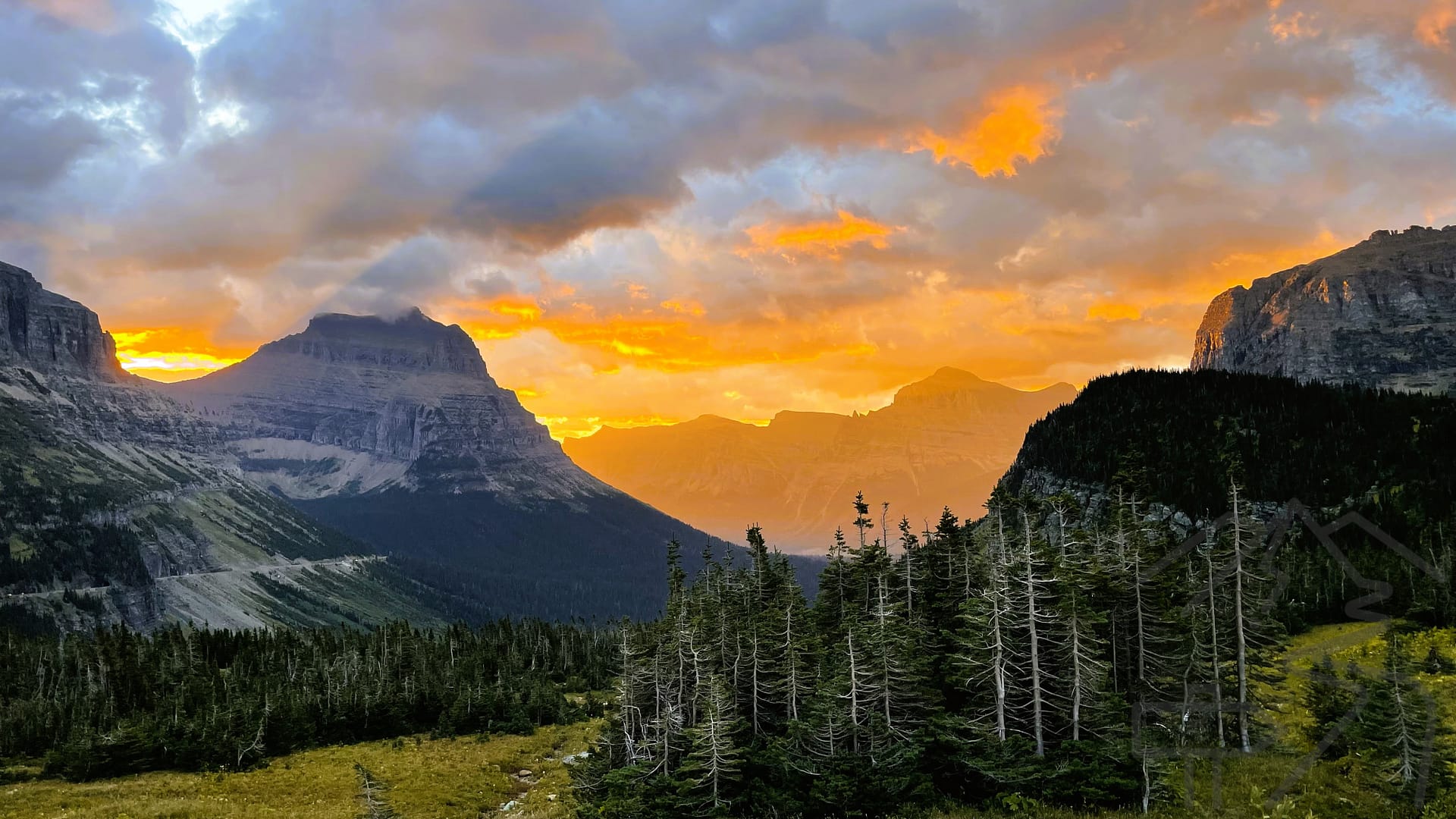 Sunrise over mountain peaks at Logan Pass on Going-to-the-Sun Road in Glacier National Park