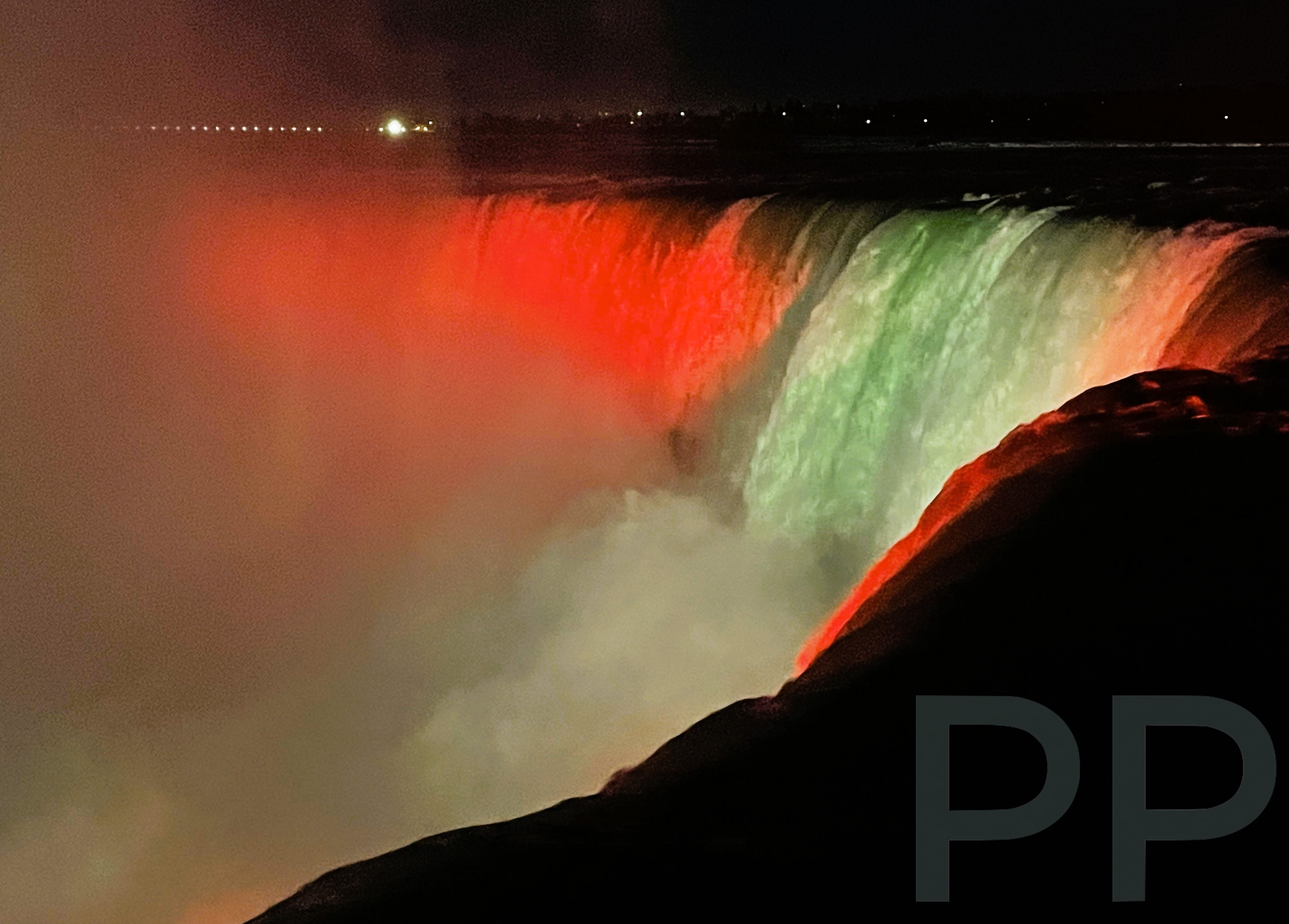 Niagara Falls illuminated in red and green at night, Ontario viewpoint