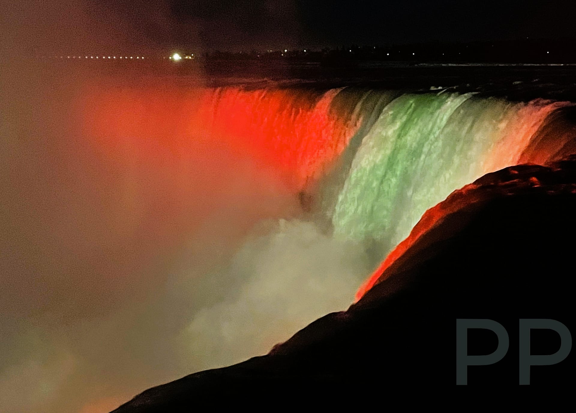 Niagara Falls illuminated in red and green at night, Ontario viewpoint
