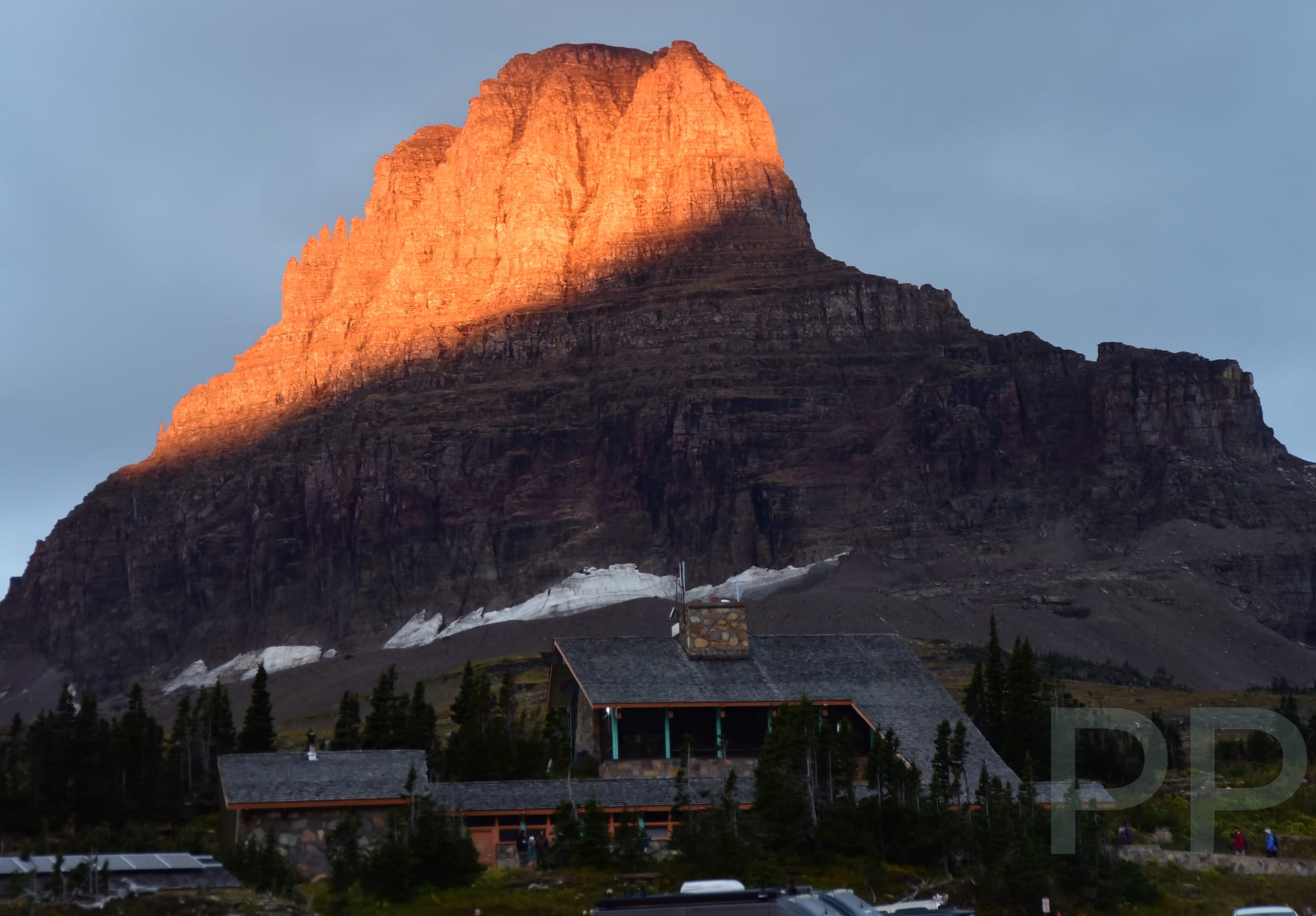 Sunrise at Logan Pass Visitor Center with Mount Reynolds in warm light.