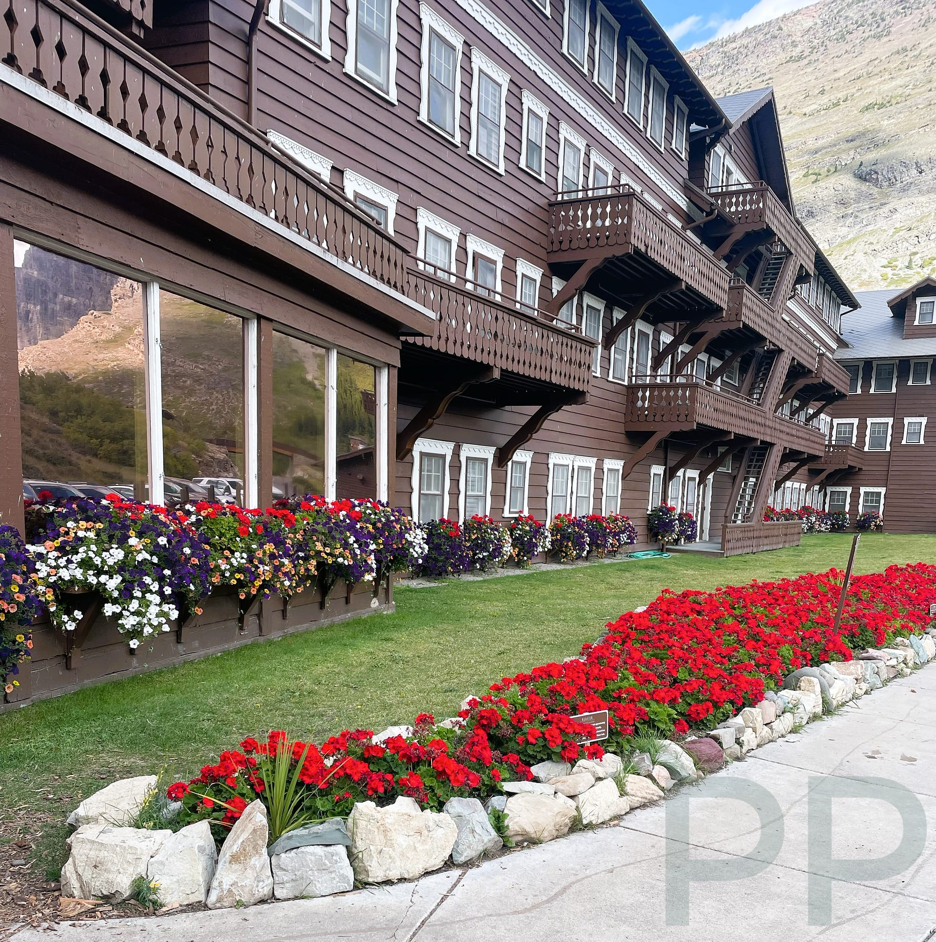 Flower-filled window boxes along the exterior of Many Glacier Hotel in Glacier National Park