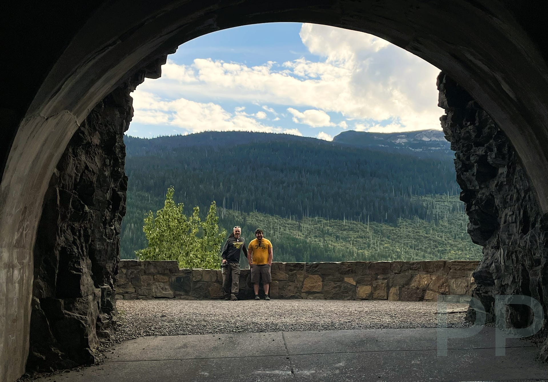 Visitors looking out through an observation window inside the West Tunnel on Going-to-the-Sun Road in Glacier National Park