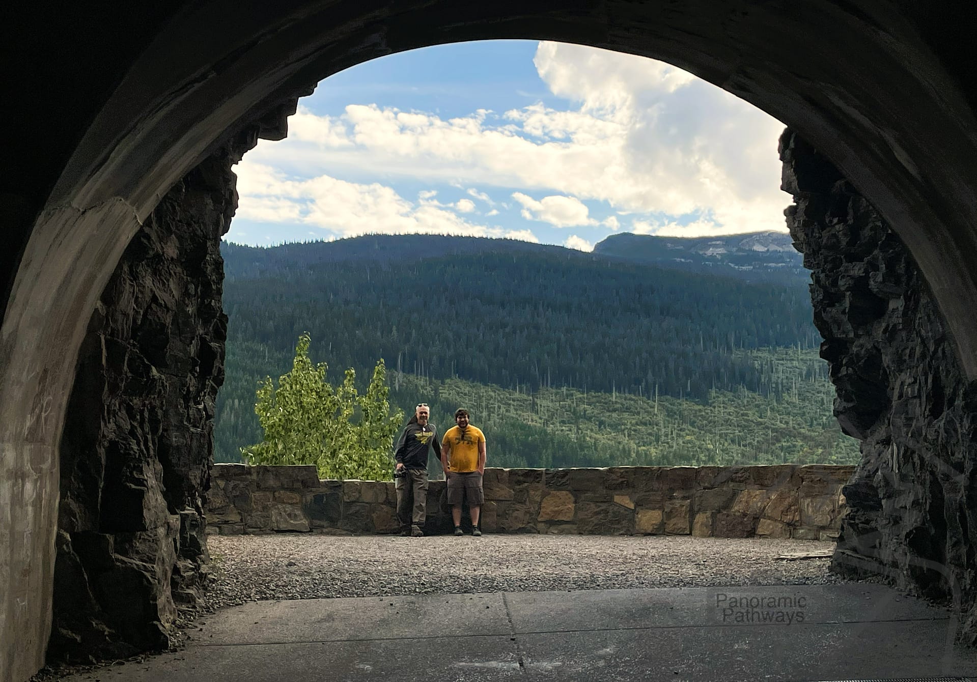 Visitors looking out through an observation window inside the West Tunnel on Going-to-the-Sun Road in Glacier National Park