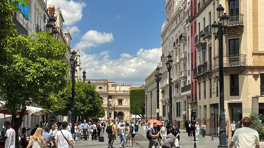 Pedestrian street in Seville with people walking between historic buildings
