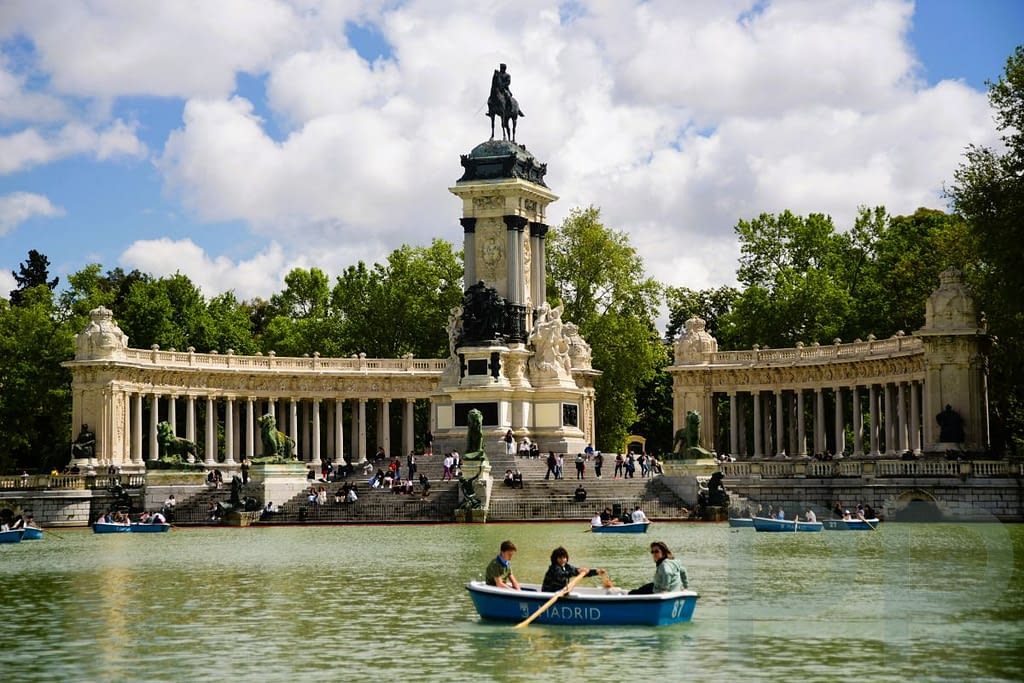 The boating lake (Estanque Grande) in Retiro Park, Madrid, with people along the water.