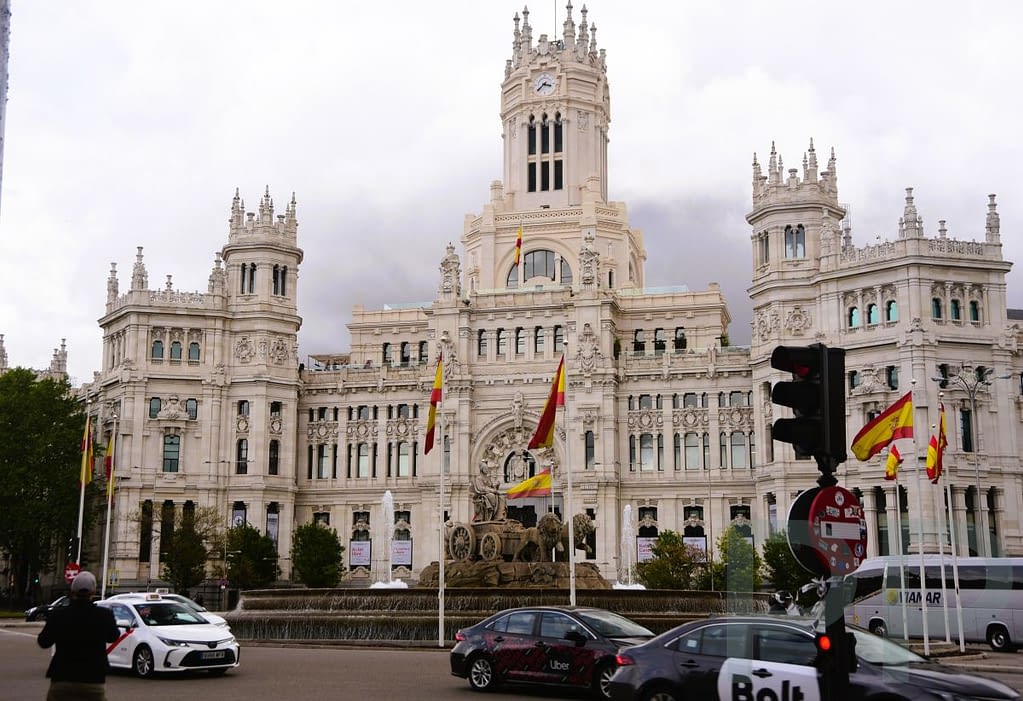Palacio de Cibeles in Madrid, a large white landmark building with ornate towers and Spanish flags.