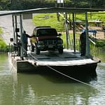 Small cable ferry transporting a vehicle across a river in rural Belize