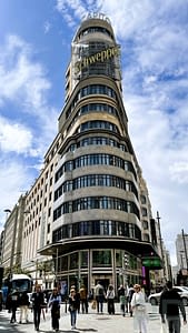 The Schweppes sign on Gran Vía in Madrid with surrounding historic buildings.