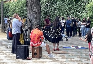 Street performer in Seville with historic buildings and pedestrians nearby