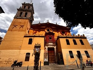Exterior of Iglesia de Santa Ana in Triana with tower and ochre facade