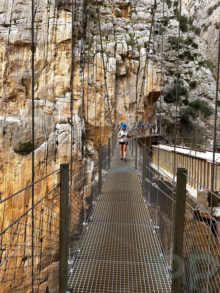 Hikers crossing the suspension bridge along the Caminito del Rey trail.