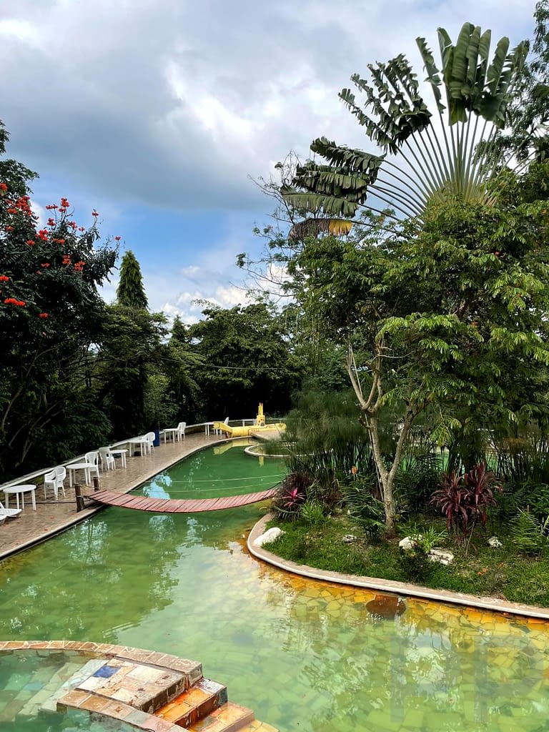 Thermal pools with stone paths and tropical plants at Termales de Santa Teresa hot springs, Ruta de las Flores, El Salvador.