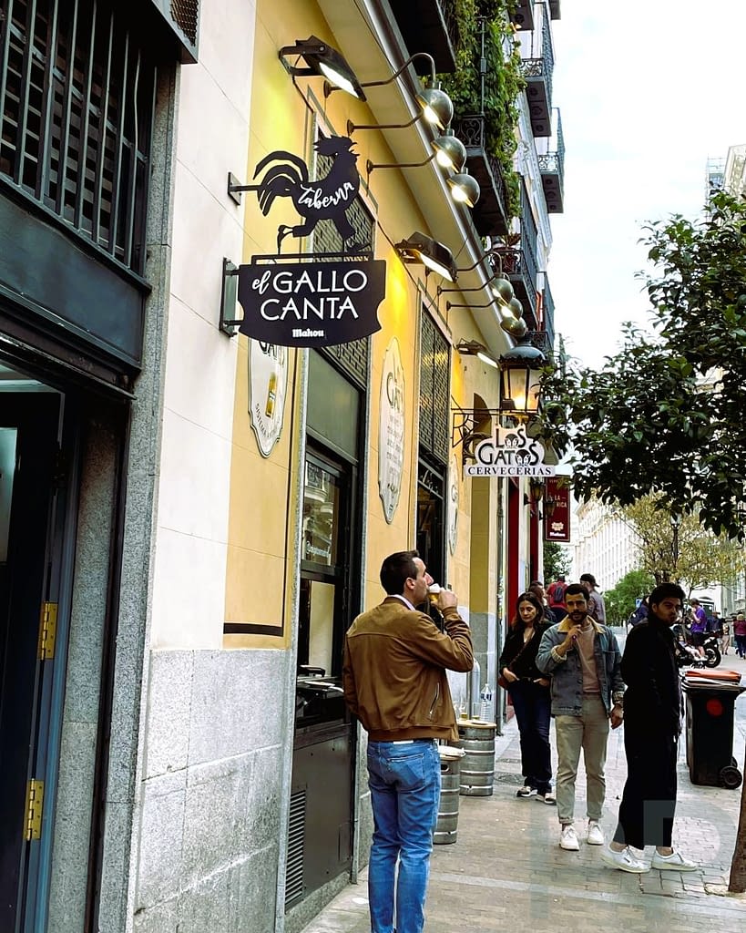 Tapas being served in a Madrid bar with plates and drinks on the counter.