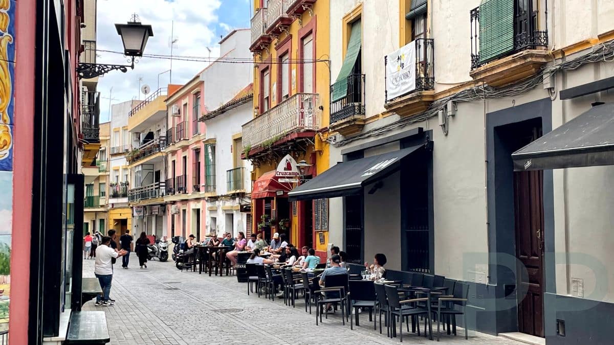 Outdoor caf&eacute; in Triana with tables, chairs, and people