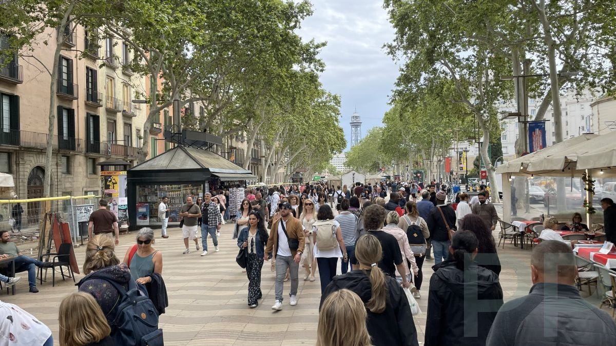 People strolling along a tree-lined street in Barcelona, reflecting the city&rsquo;s relaxed, walkable atmosphere.