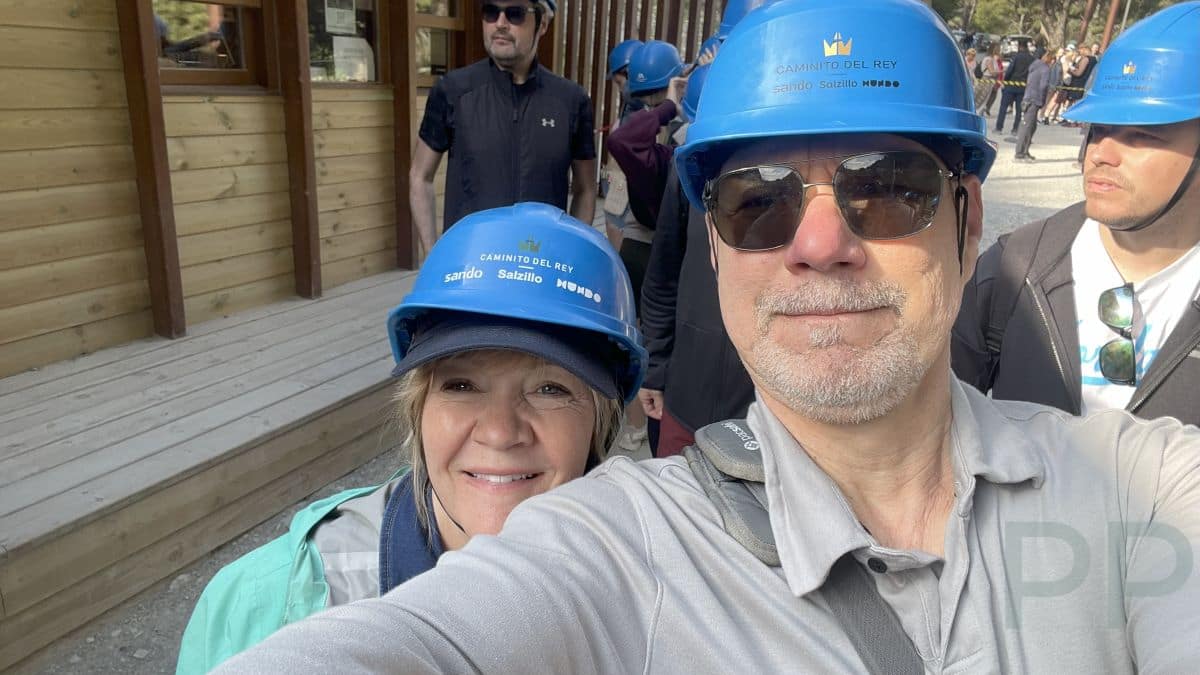 Visitors wearing helmets at the entrance gate to Caminito del Rey in Spain.