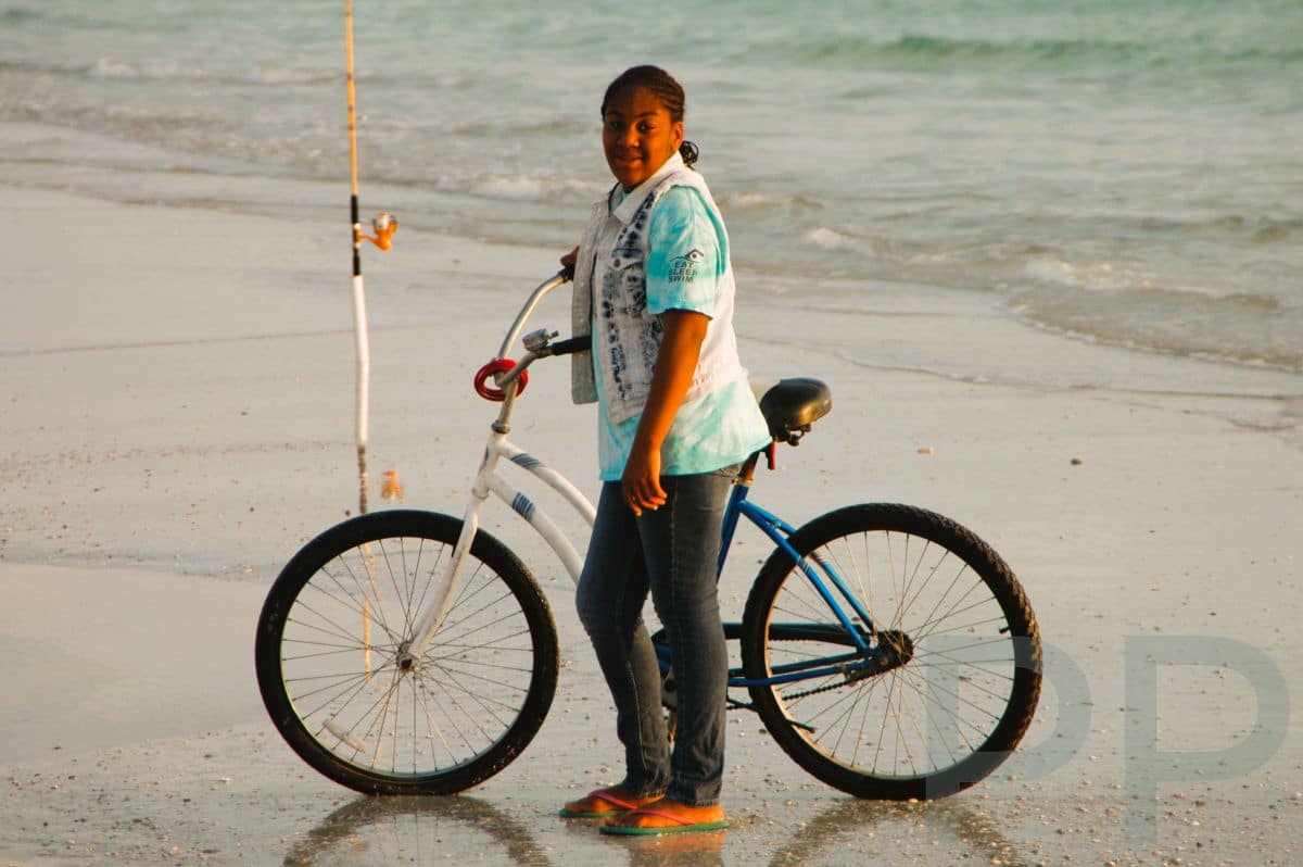 Person with bicycle on wet sand along the beach at Anna Maria Island.