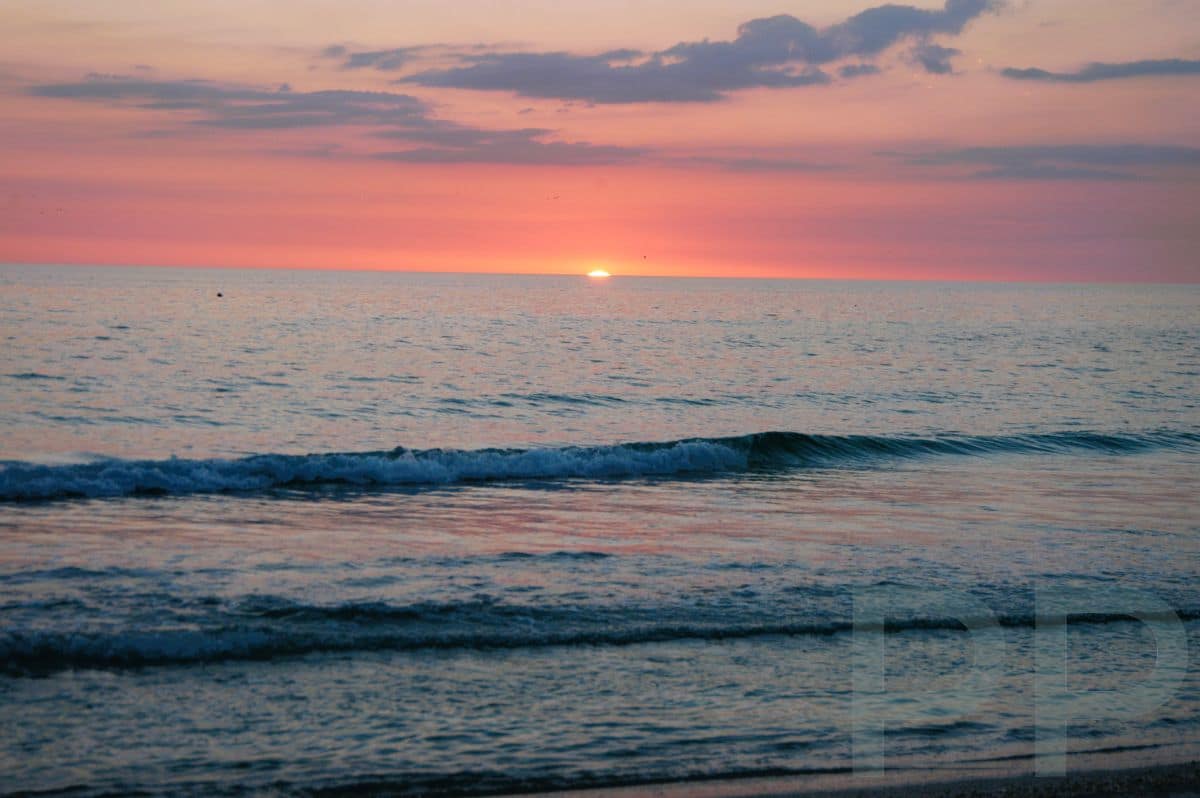 Pink and lavender sunset over calm Gulf waters at Anna Maria Island.