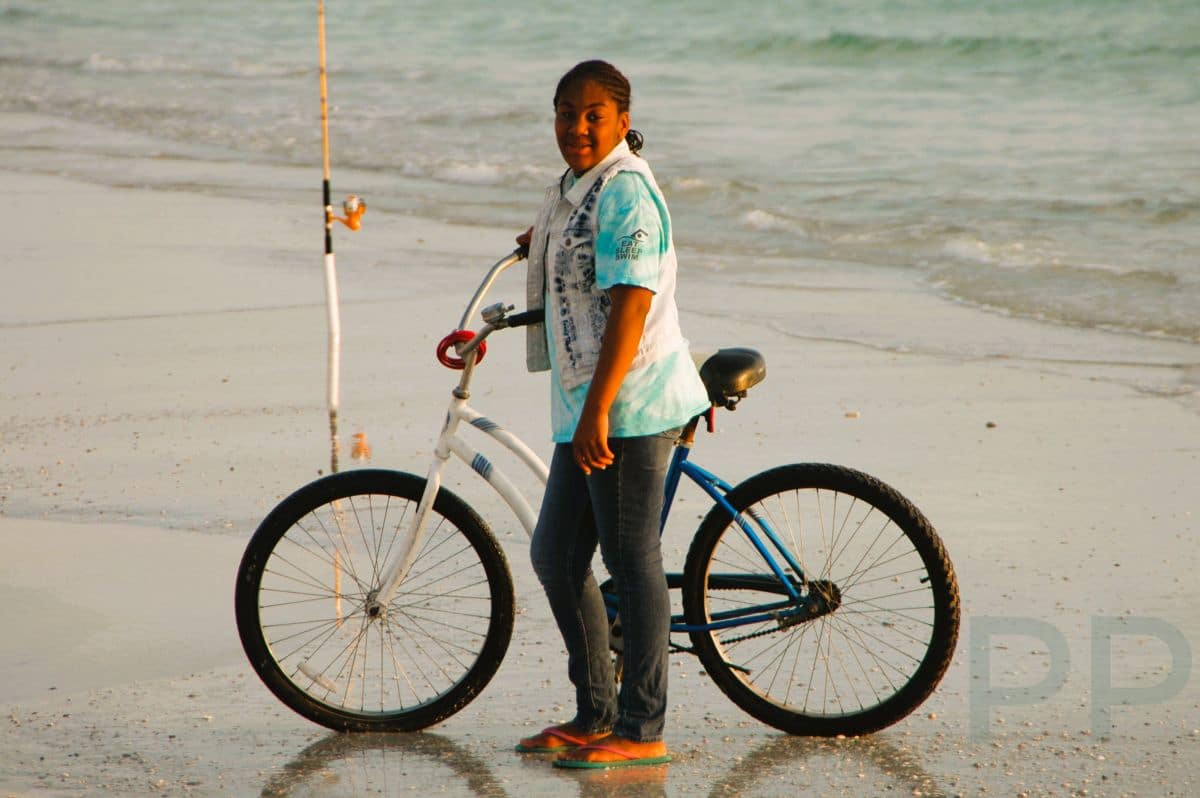 Person with bicycle on wet sand along the beach at Anna Maria Island.