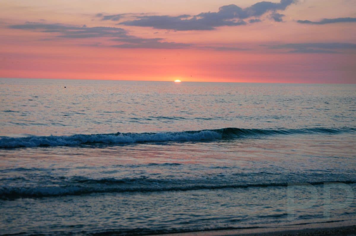 Pink and lavender sunset over calm Gulf waters at Anna Maria Island.
