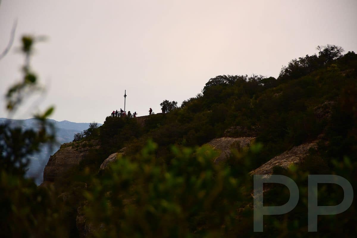 Sant Jeroni summit cross visible on a distant ridge in the Montserrat mountains