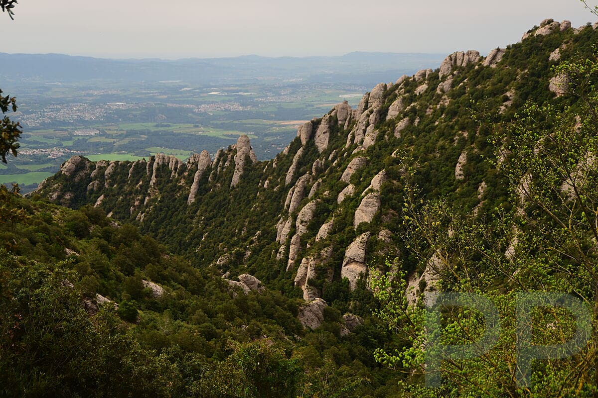 Jagged rock formation with panoramic views of the countryside below Montserrat