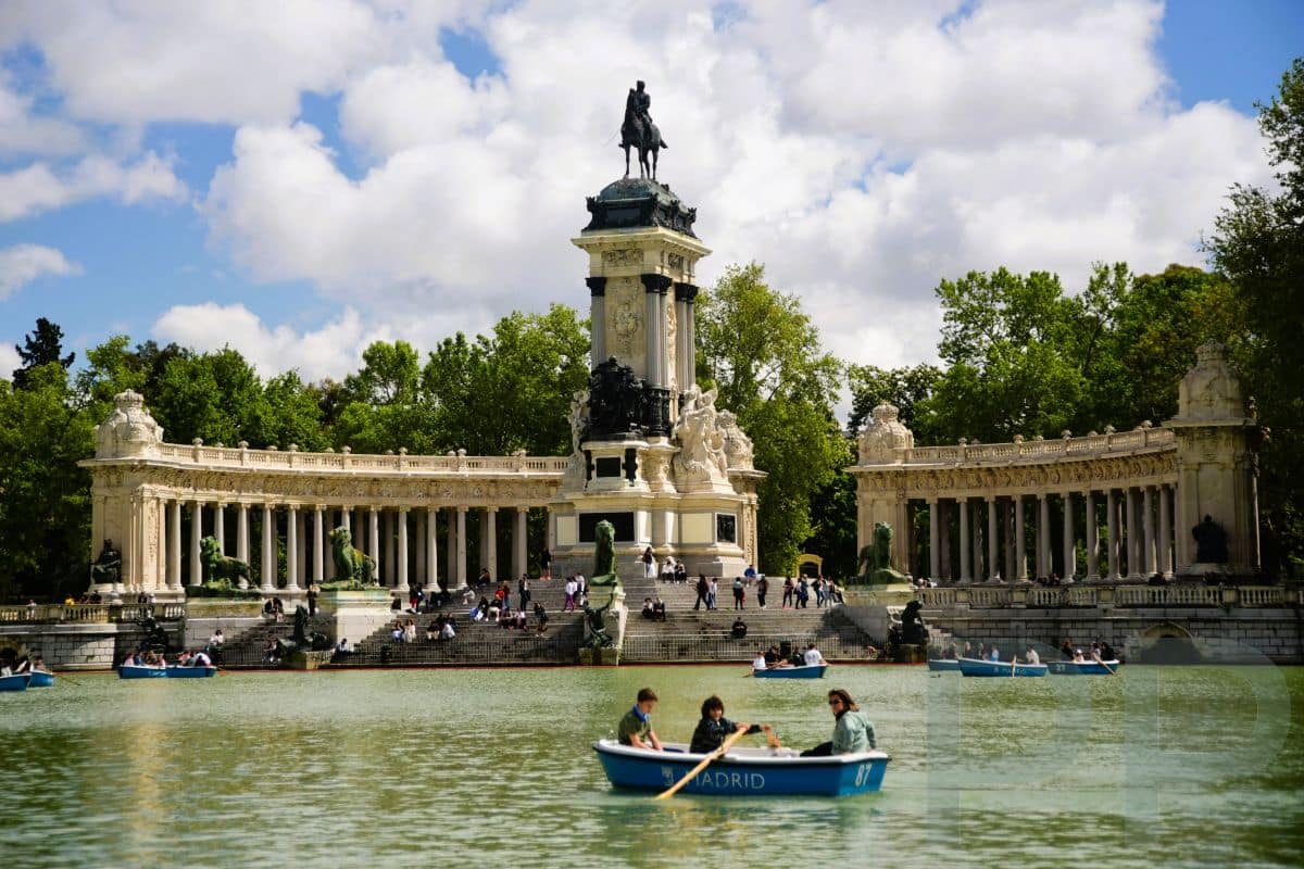 The boating lake (Estanque Grande) in Retiro Park, Madrid, with people along the water.