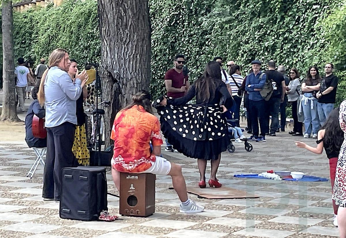 Street performer in Seville with historic buildings and pedestrians nearby