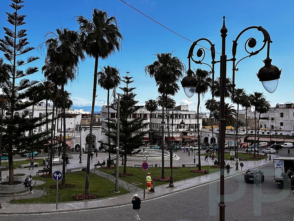 Grand Socco square with palm trees and traffic in Tangier, Morocco.