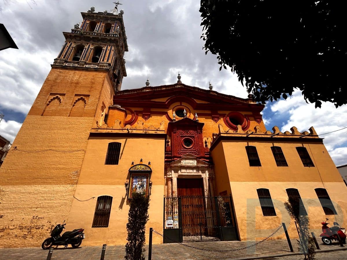 Exterior of Iglesia de Santa Ana in Triana with tower and ochre facade