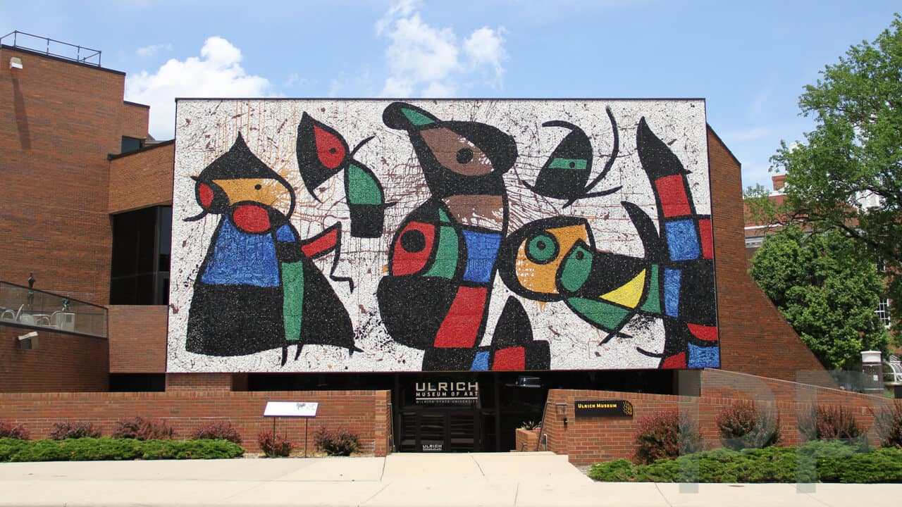 Mosaic mural &ldquo;Personnages Oiseaux&rdquo; by Joan Mir&oacute; on the fa&ccedil;ade of the Ulrich Museum of Art at Wichita State University, featuring bold abstract figures in bright red, blue, green, black, and yellow.