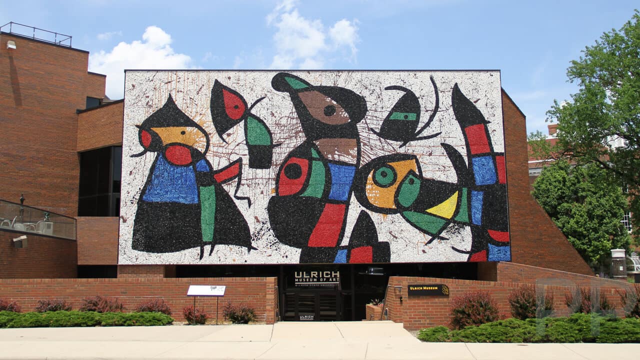 Mosaic mural &ldquo;Personnages Oiseaux&rdquo; by Joan Mir&oacute; on the fa&ccedil;ade of the Ulrich Museum of Art at Wichita State University, featuring bold abstract figures in bright red, blue, green, black, and yellow.