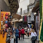 Colorful market street in Tangier, Morocco with stalls selling spices, textiles, and goods