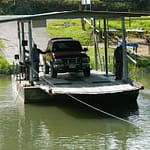 Small cable ferry transporting a vehicle across a river in rural Belize