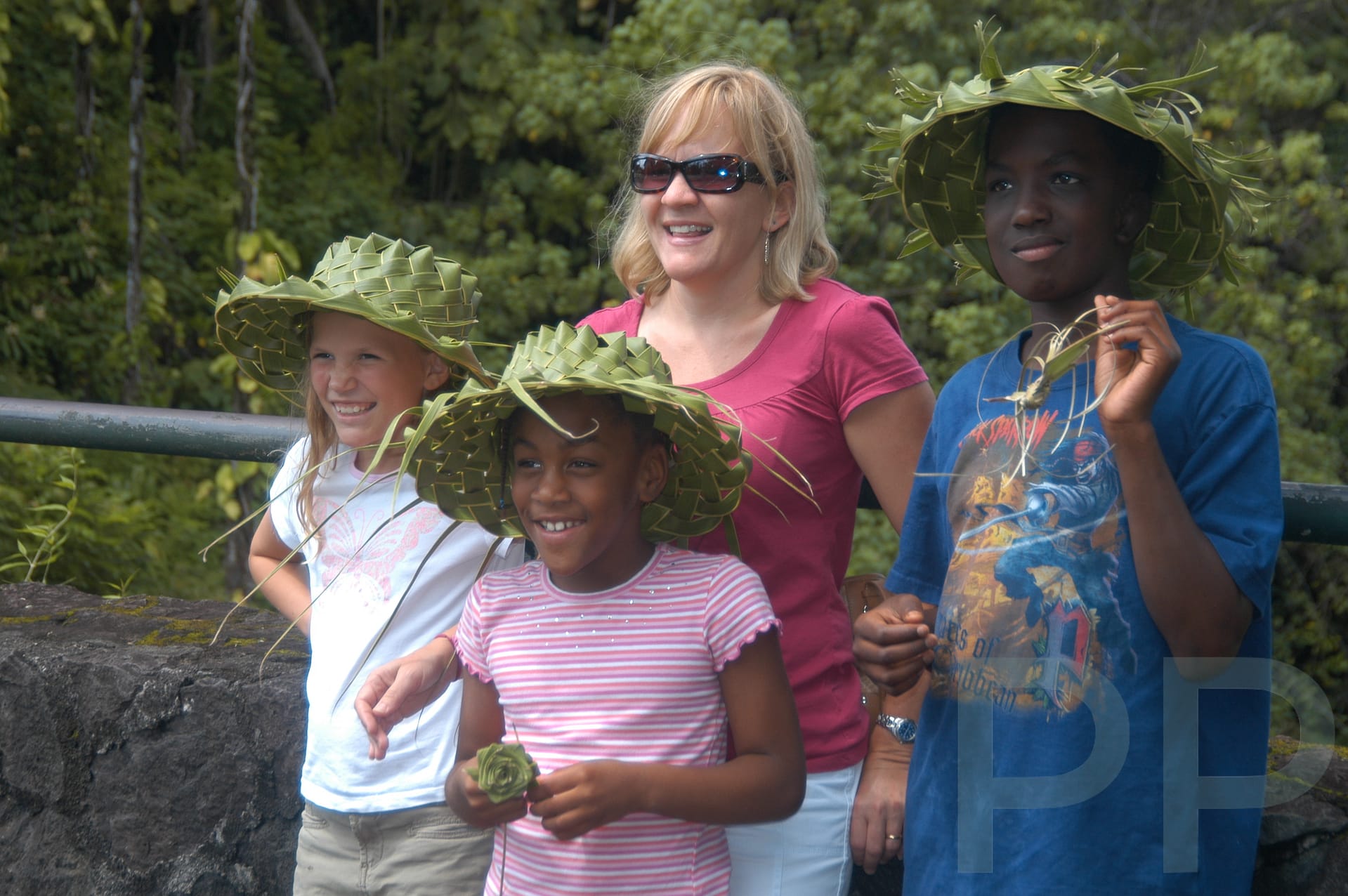 Family group smiling in handmade hats, representing shared joy and cultural discovery through travel.