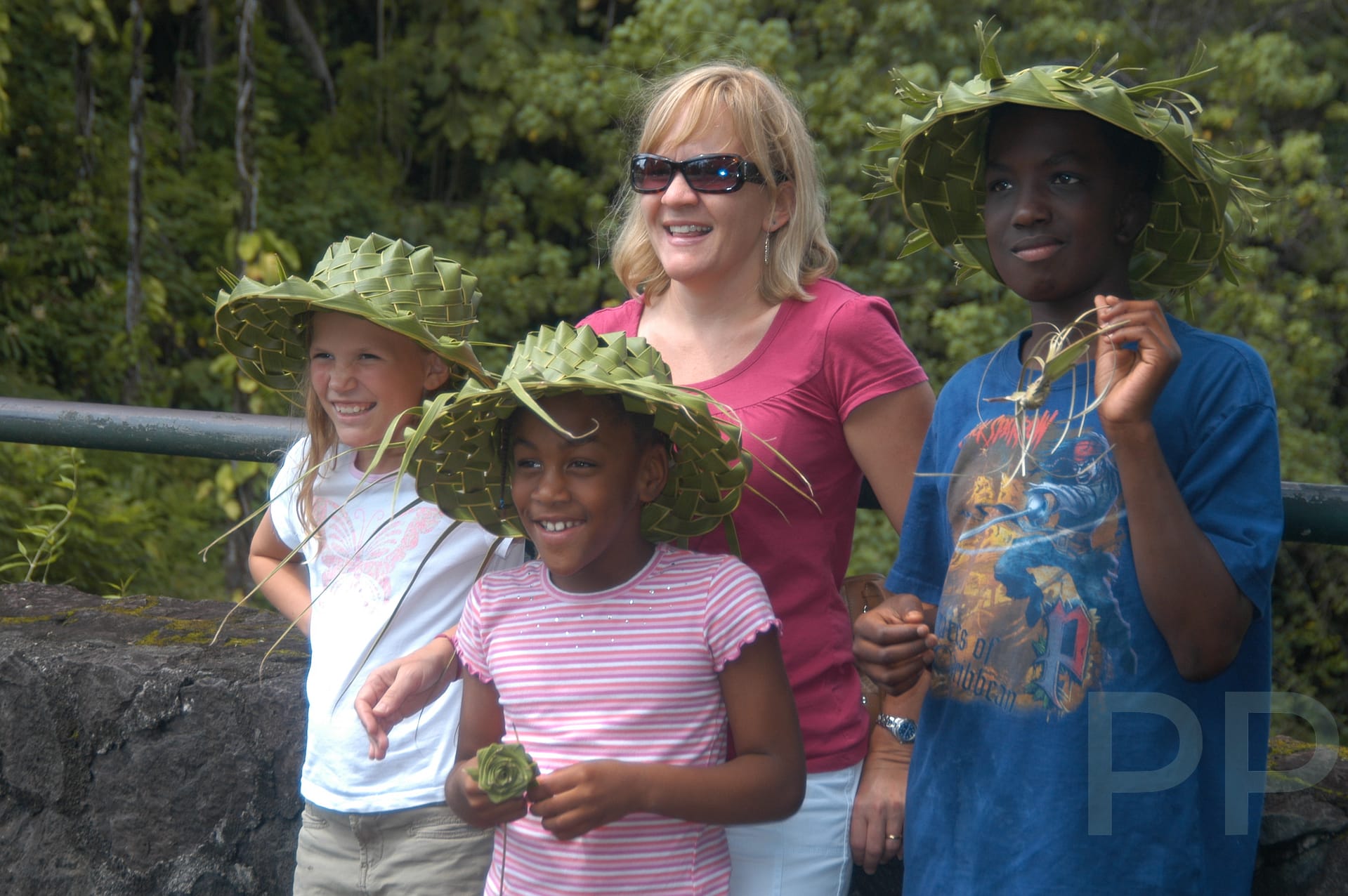 Family group smiling in handmade hats, representing shared joy and cultural discovery through travel.