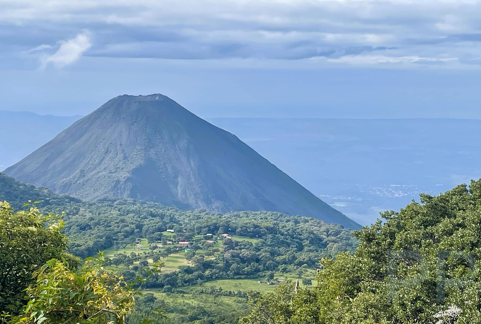 Distant view of Santa Ana Volcano with forested slopes and valley below seen from Cerro Verde National Park.