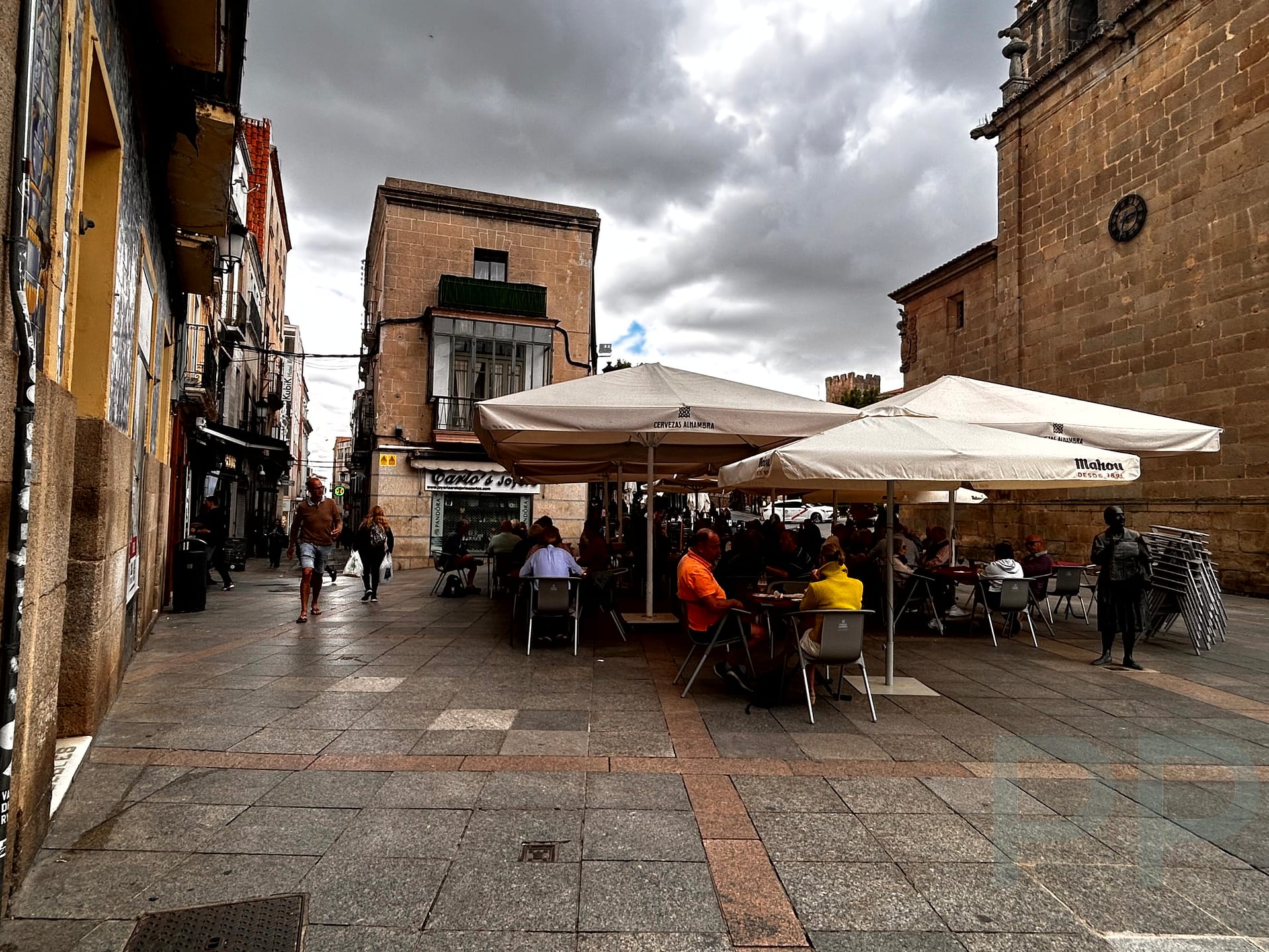 Outdoor dining in C&aacute;ceres' Plaza Mayor, showcasing local tapas and vibrant caf&eacute; culture.