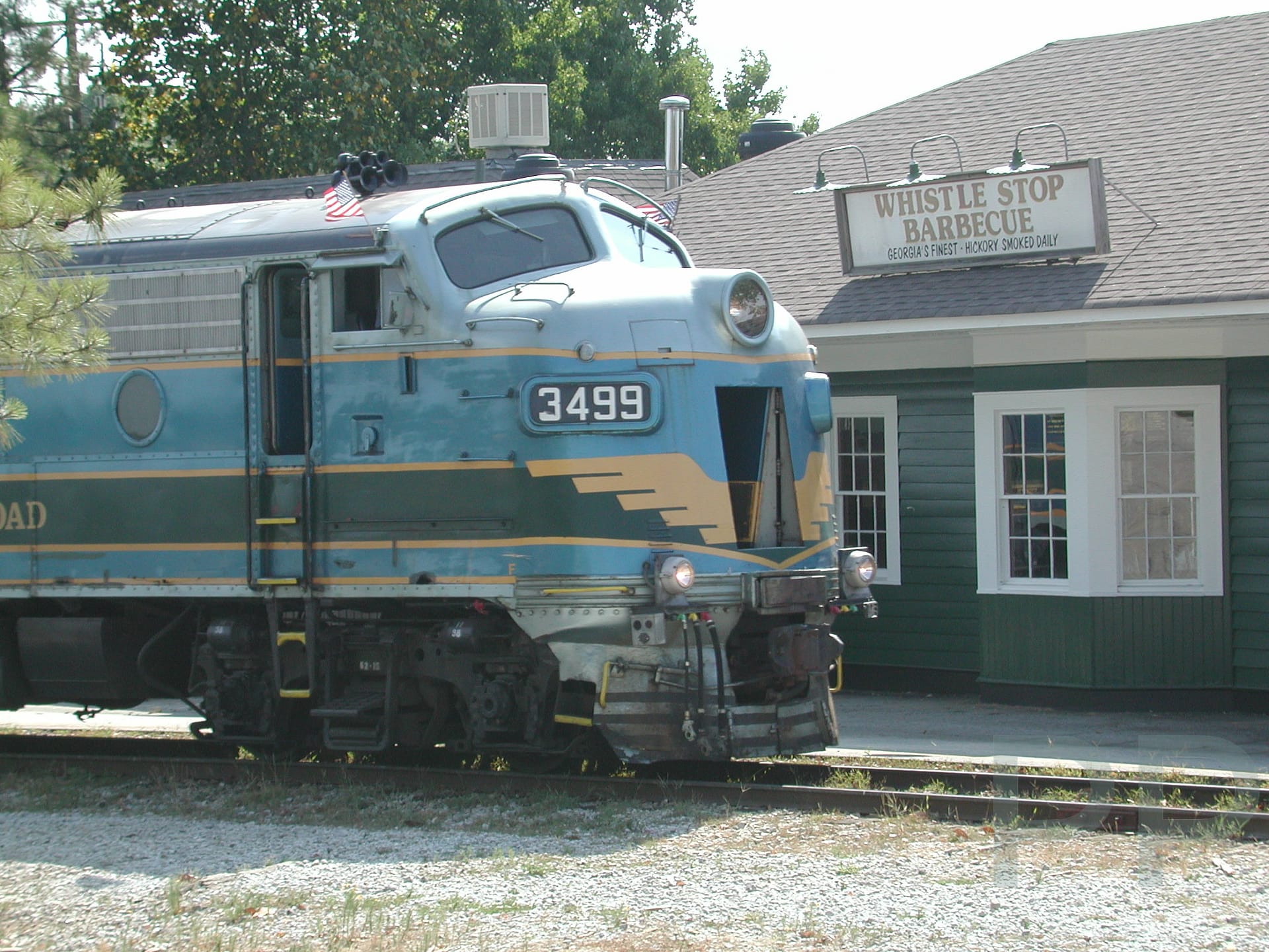 Vintage locomotive of the Stone Mountain Scenic Railroad passing Whistle Stop Barbecue station.