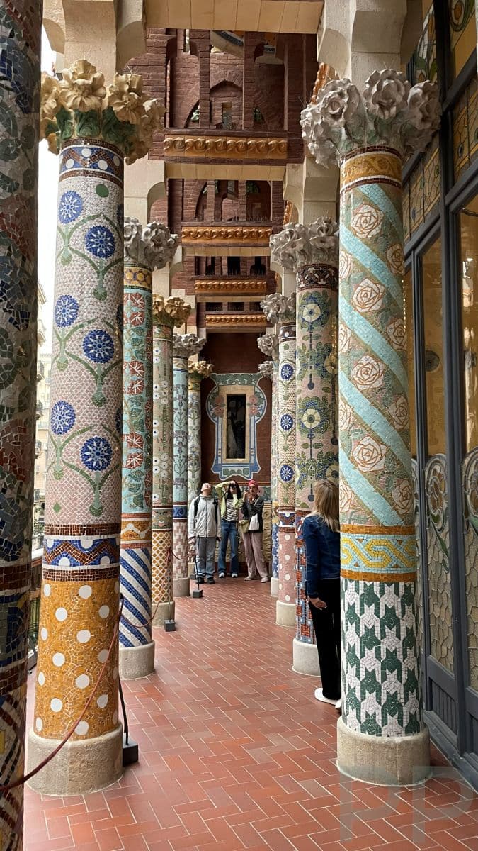 Mosaic-covered columns at the Palau de la M&uacute;sica Catalana in Barcelona, decorated with floral patterns and colorful ceramic tiles in the Modernisme style.