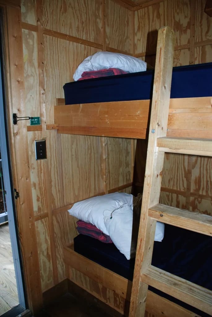 Wooden bunk beds with folded linens inside a private room at the Len Foote Hike Inn in North Georgia.