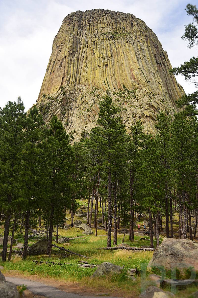 Visitors walking on the paved Tower Trail beneath Devils Tower National Monument