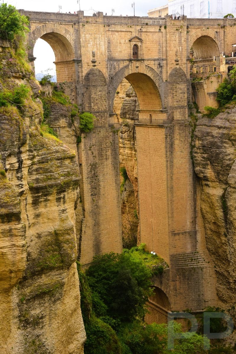 Detailed view of Puente Nuevo’s stone arches rising above the deep El Tajo Gorge in Ronda, Spain.